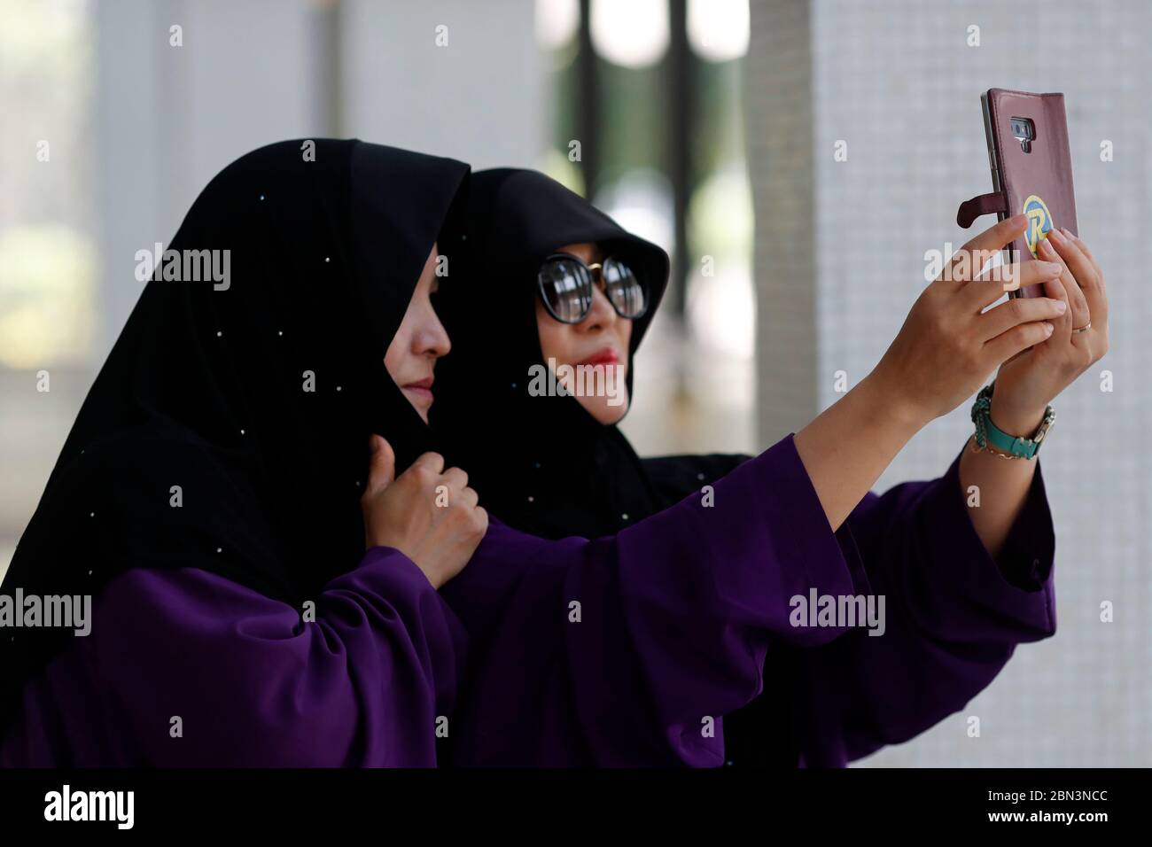 The National Mosque or Masjid Negara. Muslim women doing selfie.  Kuala Lumpur. Malaysia. Stock Photo