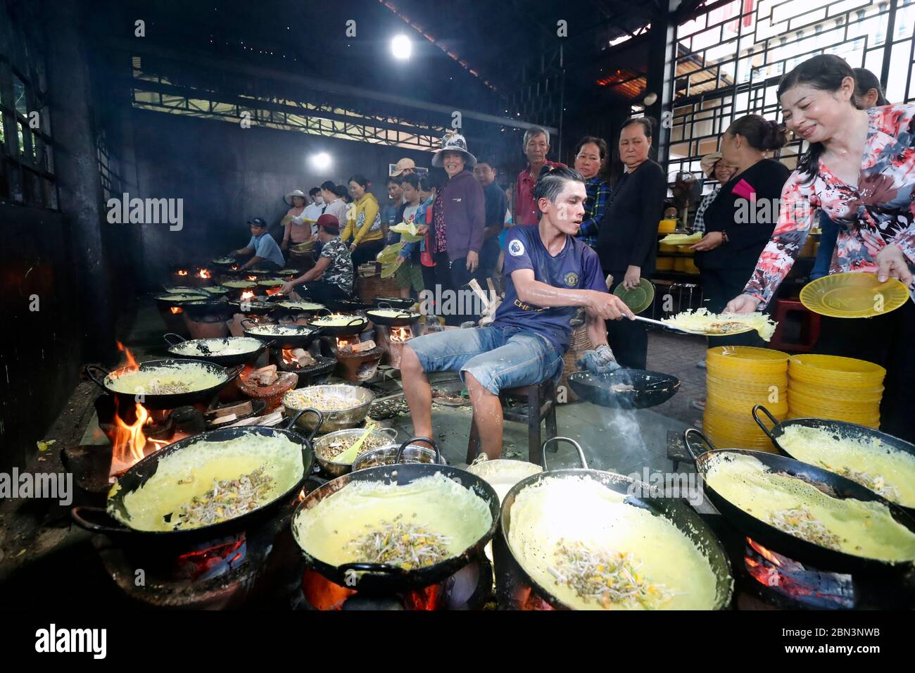 Man cooking Ban Xeo ( Vietnamese pan cakes ).  Huynh Quang Buddhist temple.  Chau Doc. Vietnam. Stock Photo