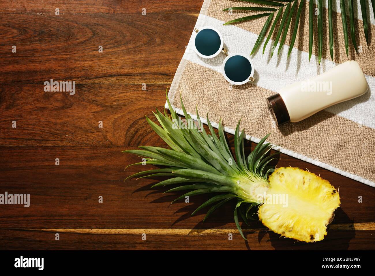 Different items for beach vacations. Sunscreen, sunglasses and pineapple fruit Stock Photo