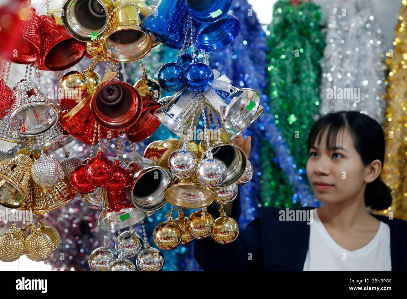 Decoration at christmas market.  Woman buying bells. Stock Photo
