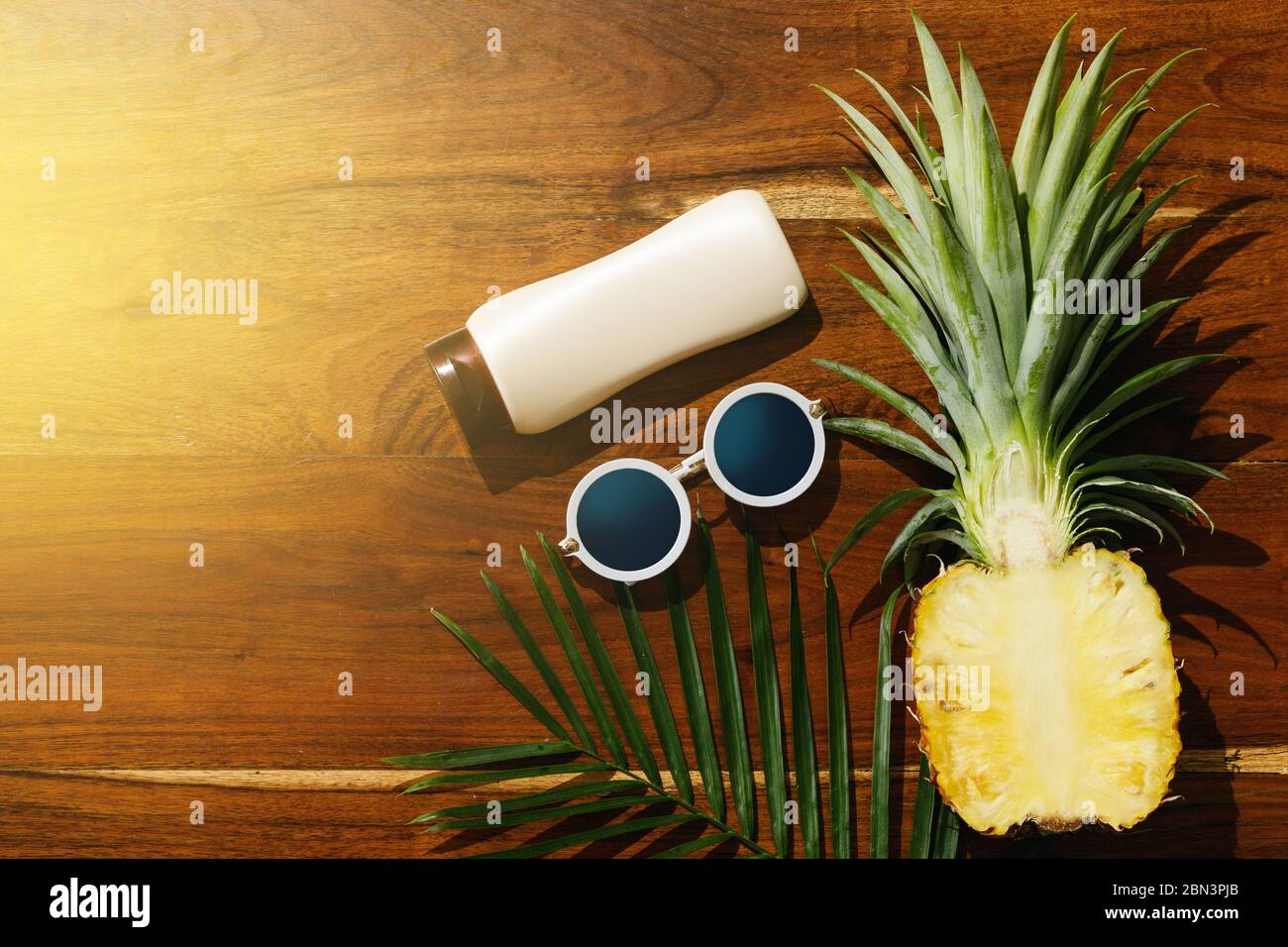 Different items for beach vacations. Sunscreen, sunglasses and pineapple fruit Stock Photo