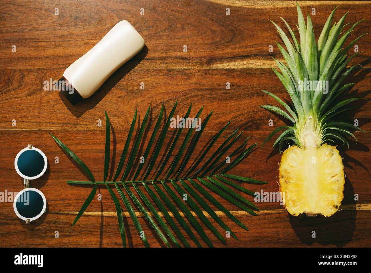 Different items for beach vacations. Sunscreen, sunglasses and pineapple fruit Stock Photo
