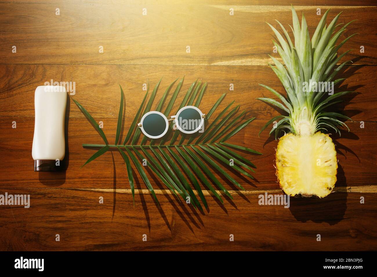Different items for beach vacations. Sunscreen, sunglasses and pineapple fruit Stock Photo