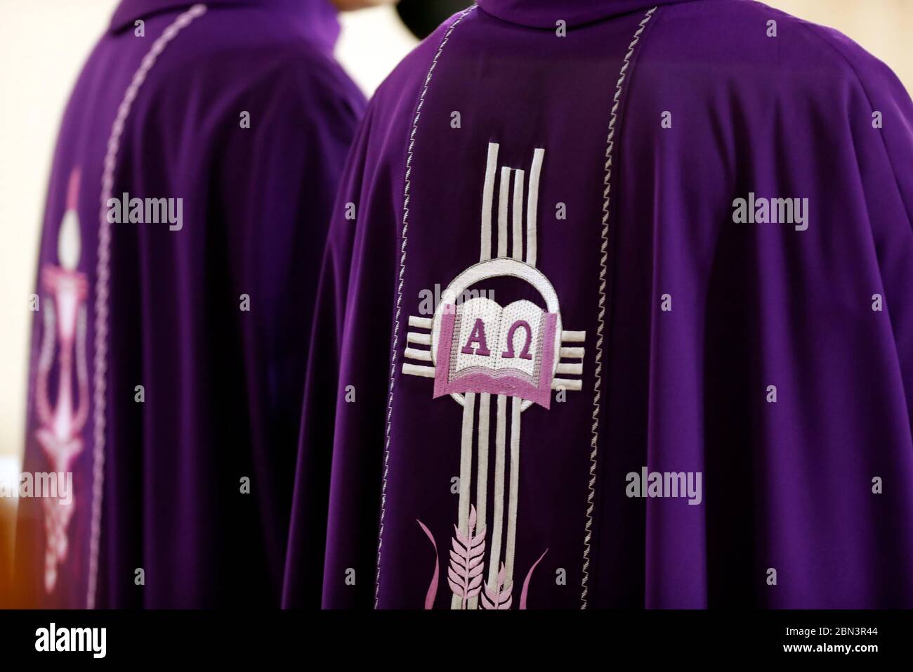 Priests wearing purple roman chasuble with Alpha and Omega embroidery
