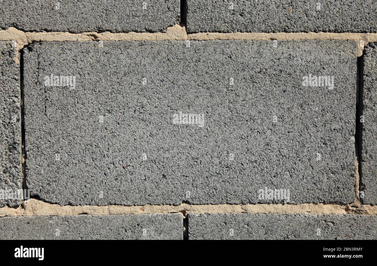 Grey brick, texture and background. Surface and blank for inscription. Mock-up. Slag (cinder) block or expanded brickwork. Slag bricks in building Stock Photo