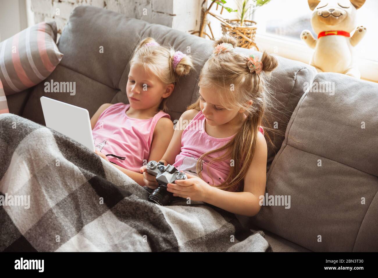 Quiet little girls playing in a bedroom in cute pajamas, home style and  comfort. Cute caucasian girls in early morning, sweet dreams. Concept of  childhood, happiness, friendship, pajamas party Stock Photo 