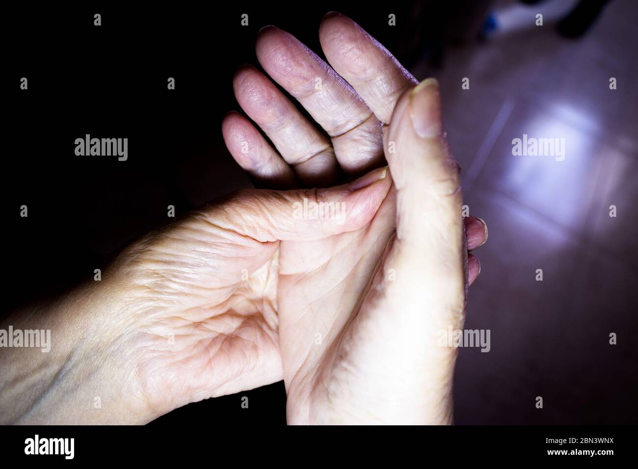 Hands of elderly woman doing a selfmassage. Manual physiotherapy Stock Photo
