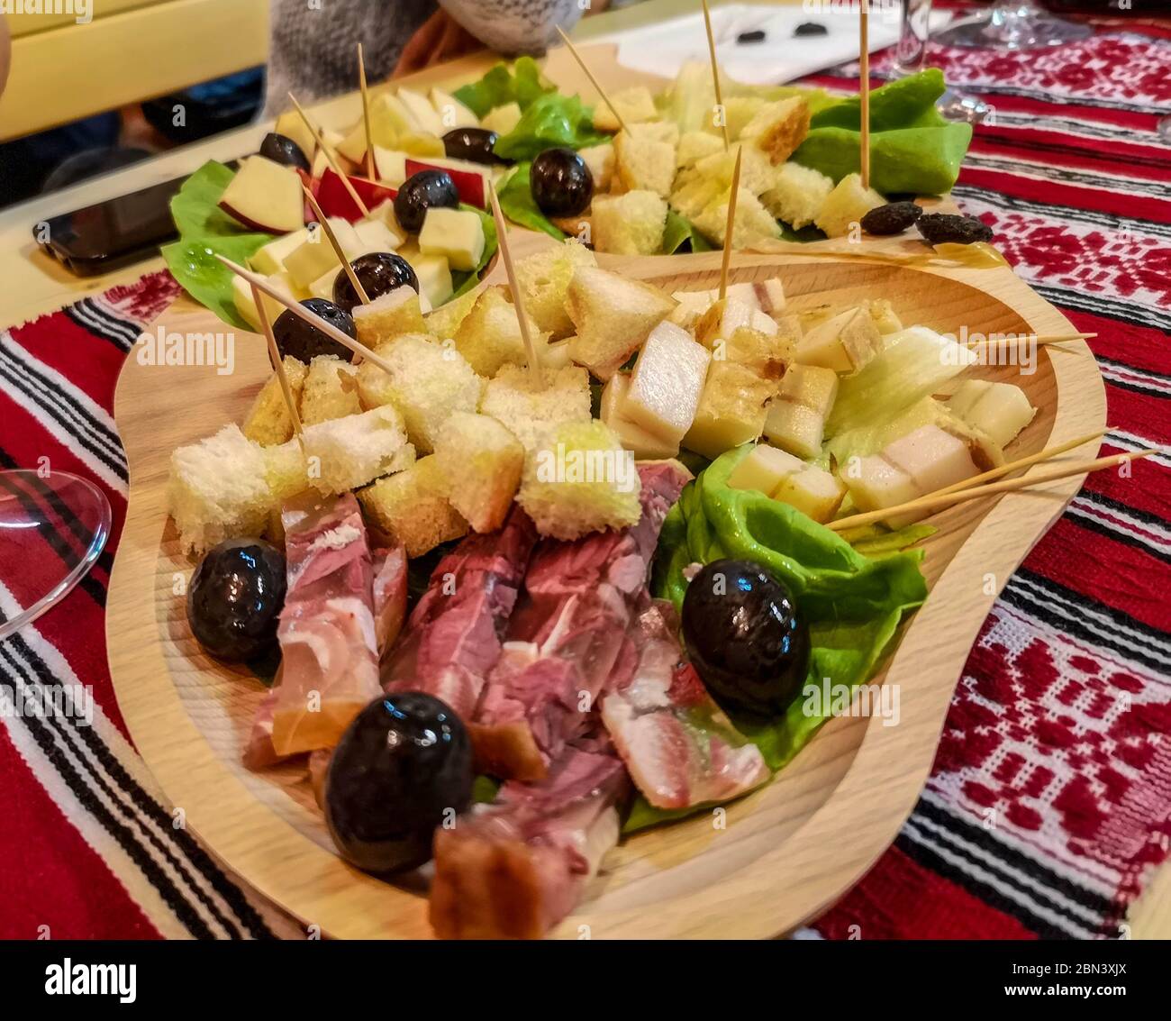 A rustic platter with cold cuts ham, cheese, olives and other