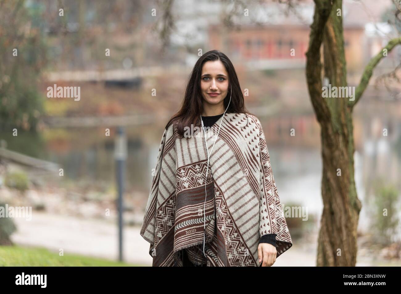 Young Indian woman model poncho for fall collection outdoors. Stock Photo