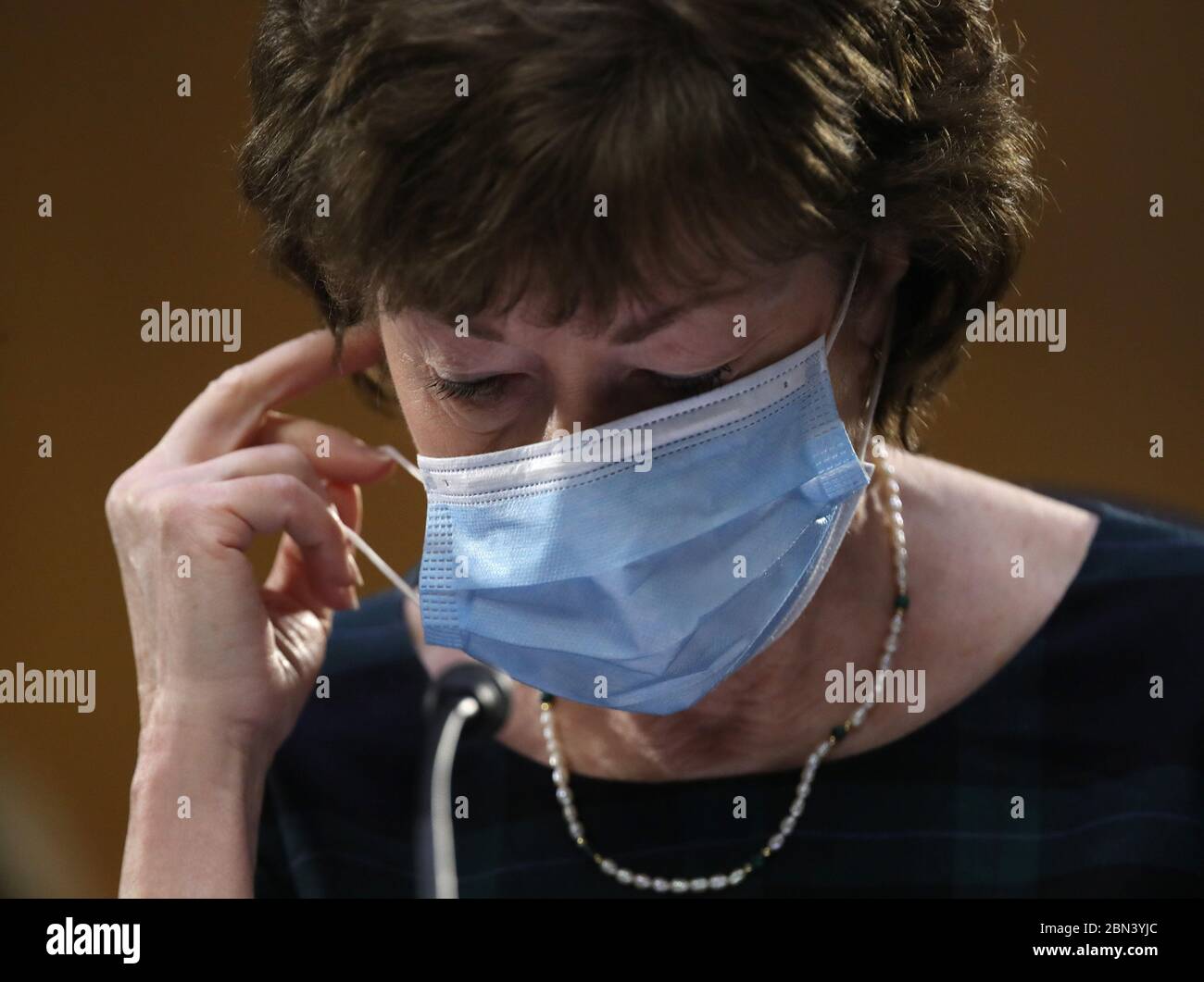 Washington, United States. 12th May, 2020. Sen. Susan Collins (R-ME) takes off her mask before speaking during in a Senate Health, Education, Labor and Pensions Committee hearing on Capitol Hill on Tuesday, May 12, 2020 in Washington, DC. The committee is hearing testimony from members of the White House Coronavirus Task Force on how to safely reopen the country. Chairman Lamar Alexander and the witnesses are all in self-quarantine since they have been exposed to the virus. Pool Photo by Win McNamee/UPI Credit: UPI/Alamy Live News Stock Photo
