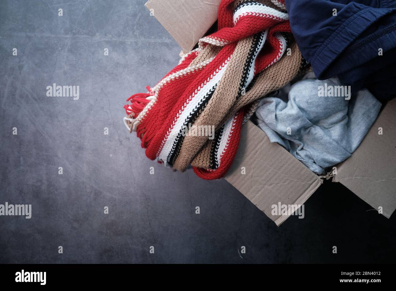 Donation box with donation clothes on a wooden table . Stock Photo