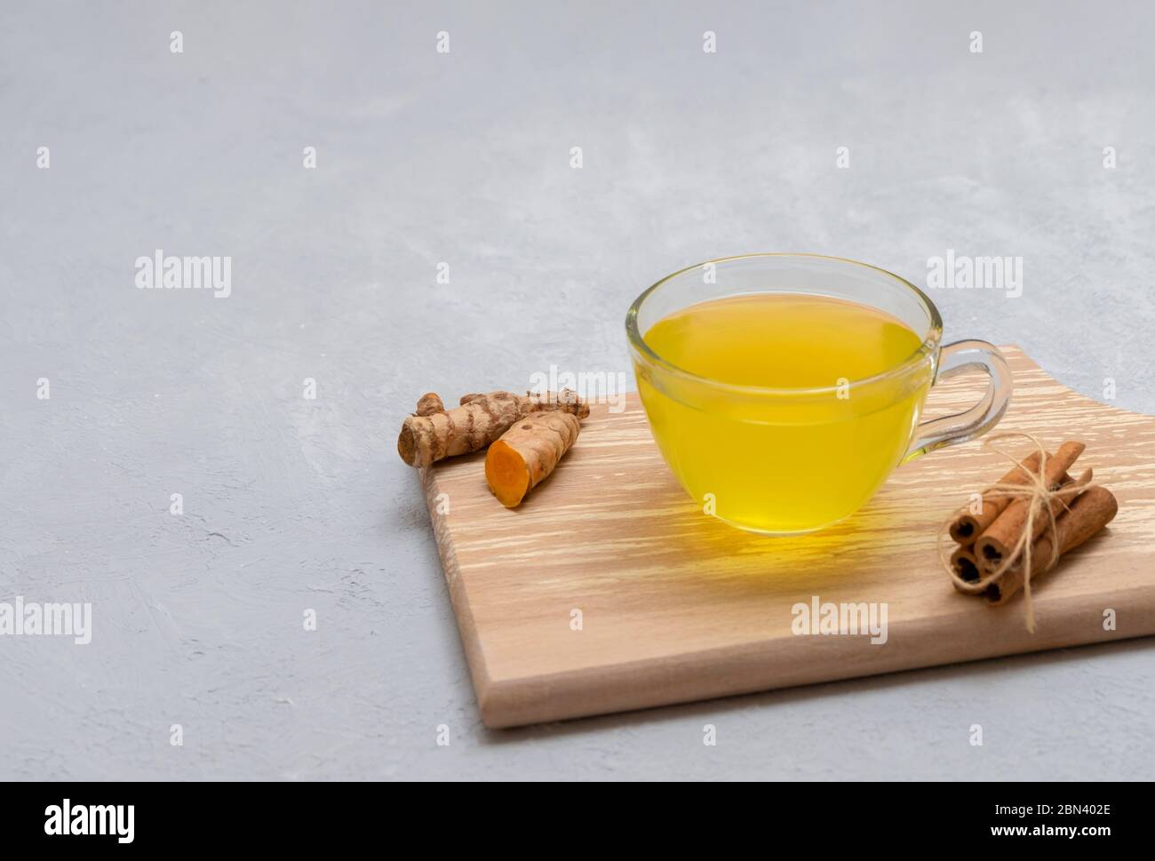 Healthy anti-inflammatory turmeric tea with cinnamon, lemon and ginger on neutral grey background with space for text Stock Photo