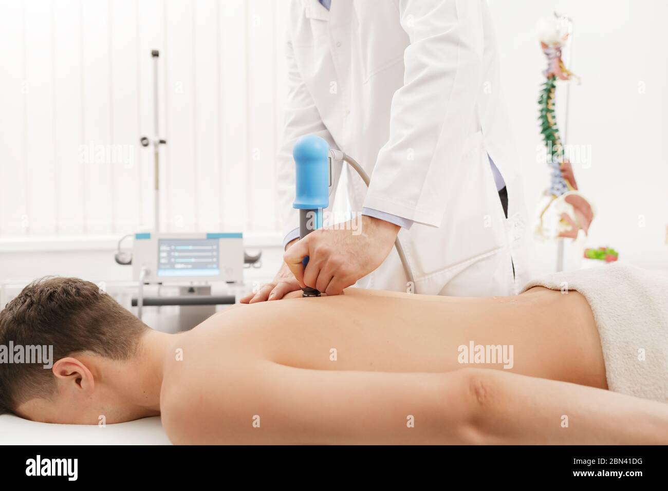 Extracorporeal Shockwave Therapy ESWT.Non-surgical treatment.Physical therapy for neck and back muscles,spine with shock waves.Pain relief Stock Photo