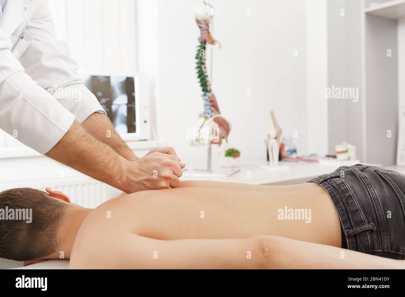 Manual therapist doing manual adjustment on patient's spine