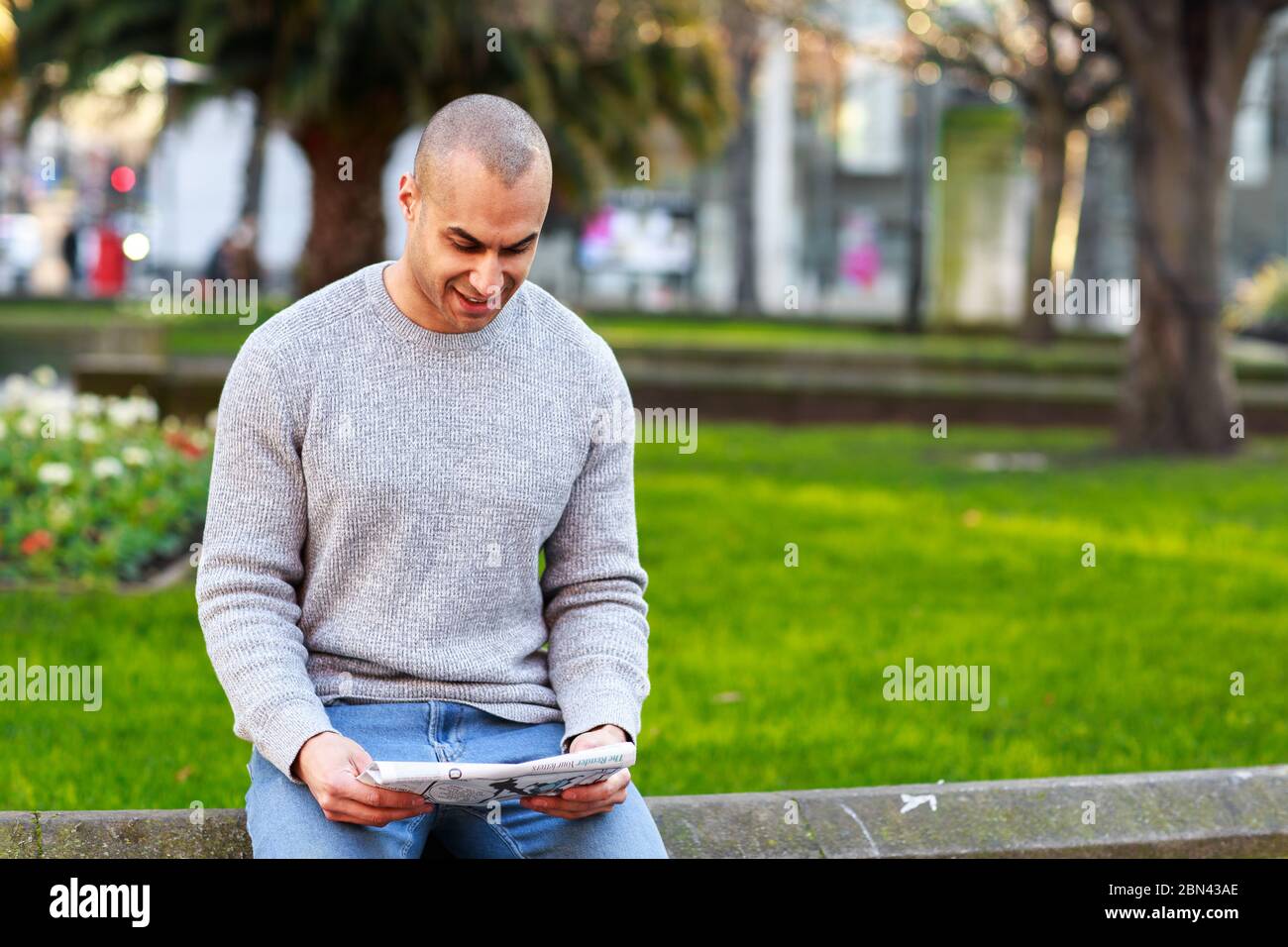 young man reading a newspaper Stock Photo - Alamy