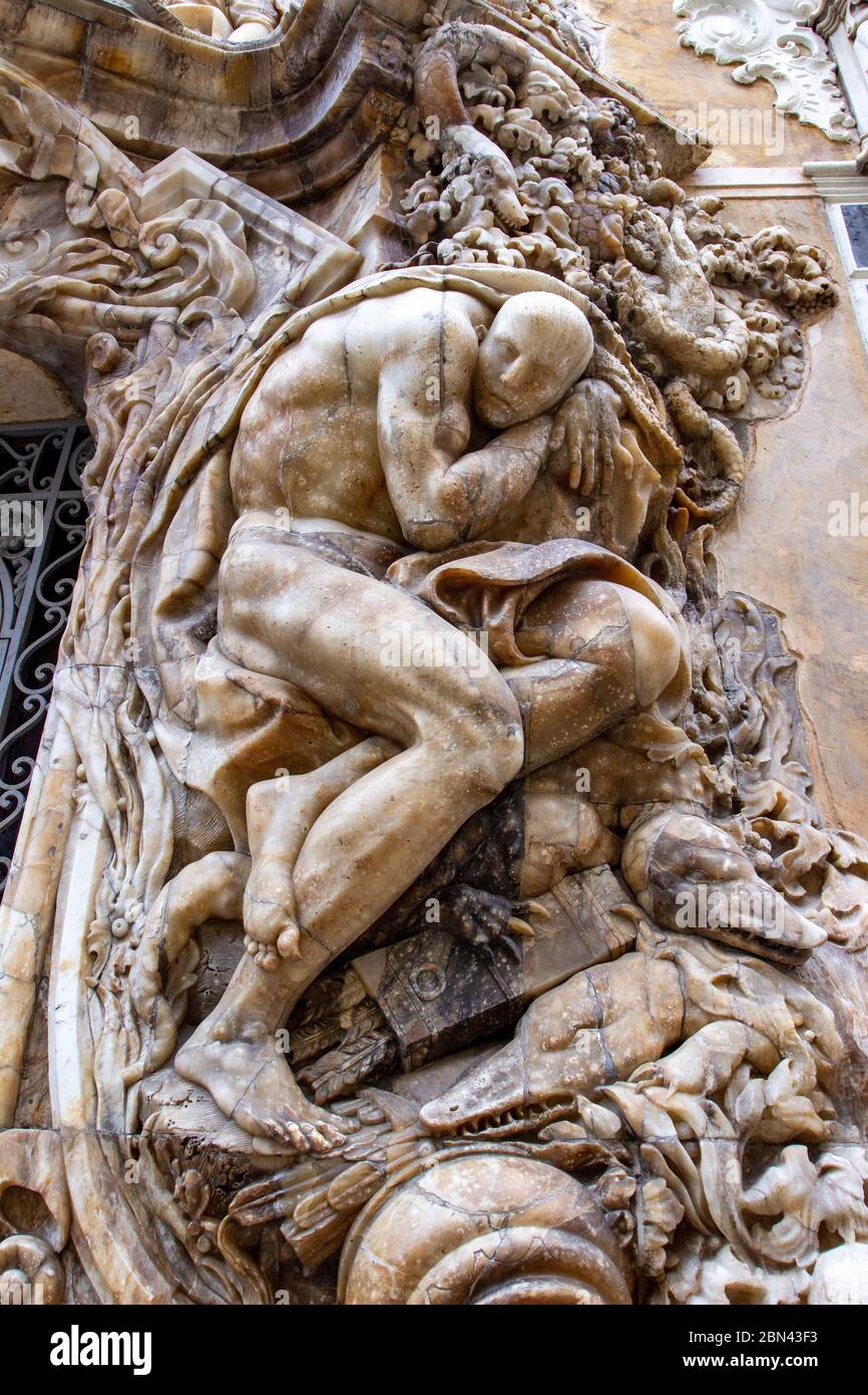 A carved human on a building in Valencia, Spain, surrounded by beasts and crocodile-like animals Stock Photo