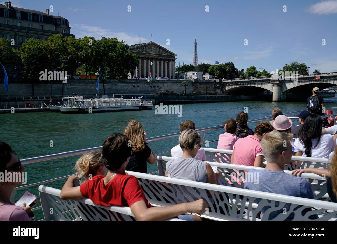 Tourists on the Bateaux-Mouches Seine river tour boat cruises in Seine river with Pont de la Concorde bridge, National Assembly building and Eiffel Tower in the background.Paris.France Stock Photo
