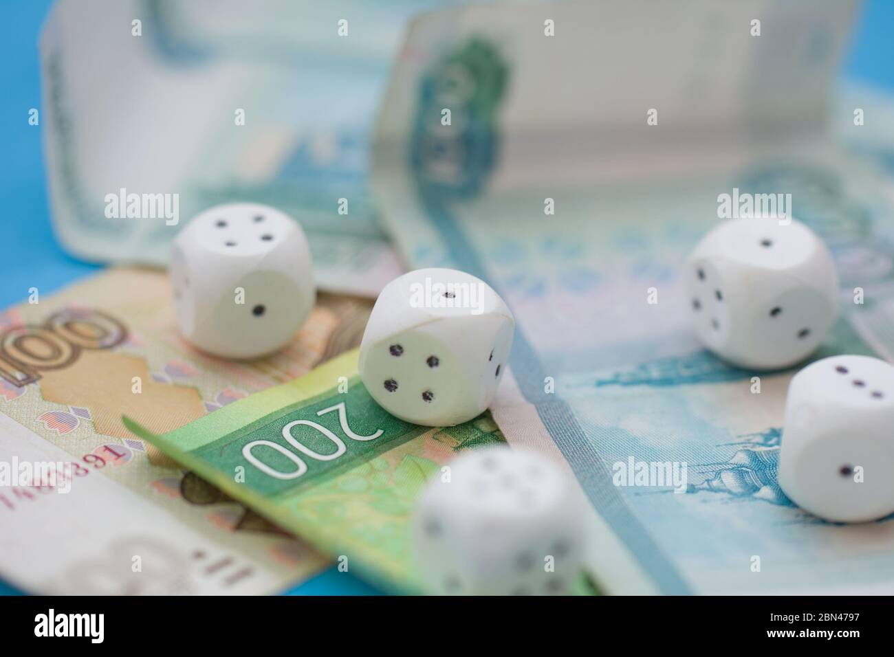Rolling Dice and the Russian money on blue background Stock Photo