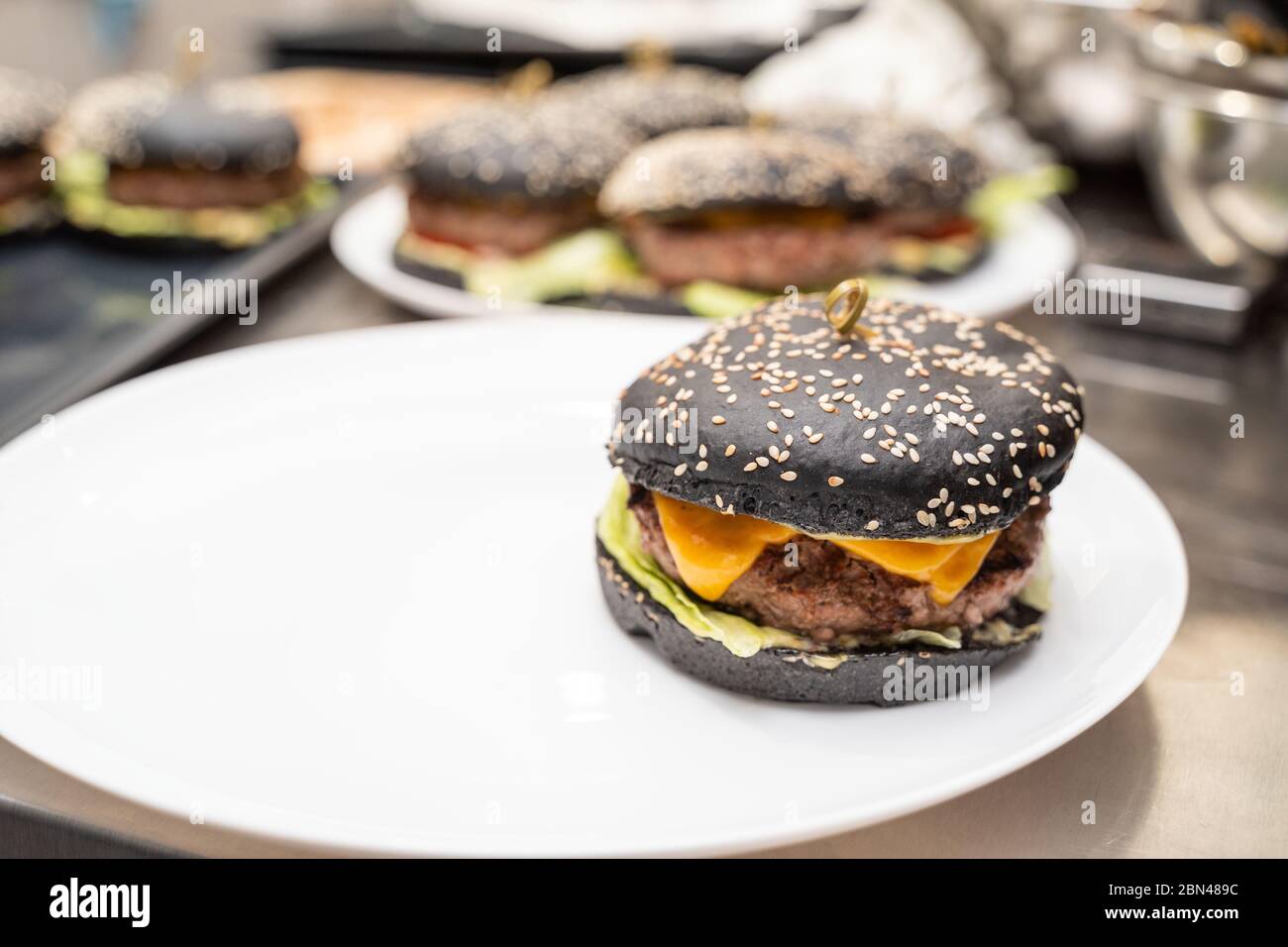 Appetizing black burger on a white plate Stock Photo