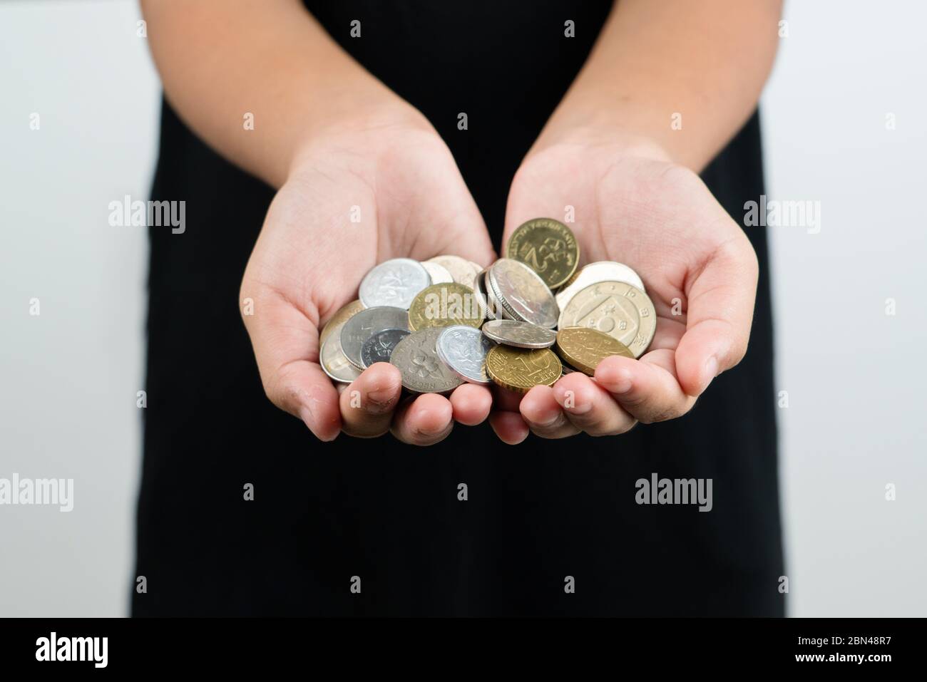 International donation concept - close up of children hands holding euro and international money coins Stock Photo