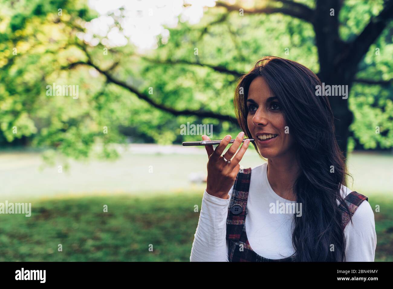 Young woman speaking a voice message on a mobile phone Stock Photo
