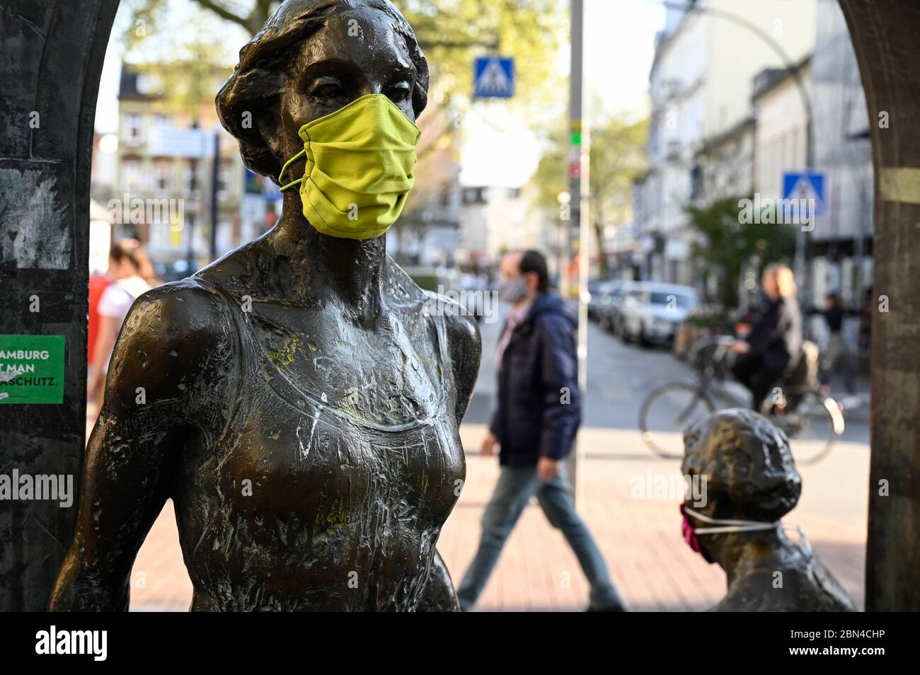 GERMANY, Hamburg, Ottensen, Corona Virus, COVID-19 , Ottenser Torbogen, two women sculpture by artist Doris Waschk-Balz , somebody has put a protective mask to protect them from Covid-19 Stock Photo