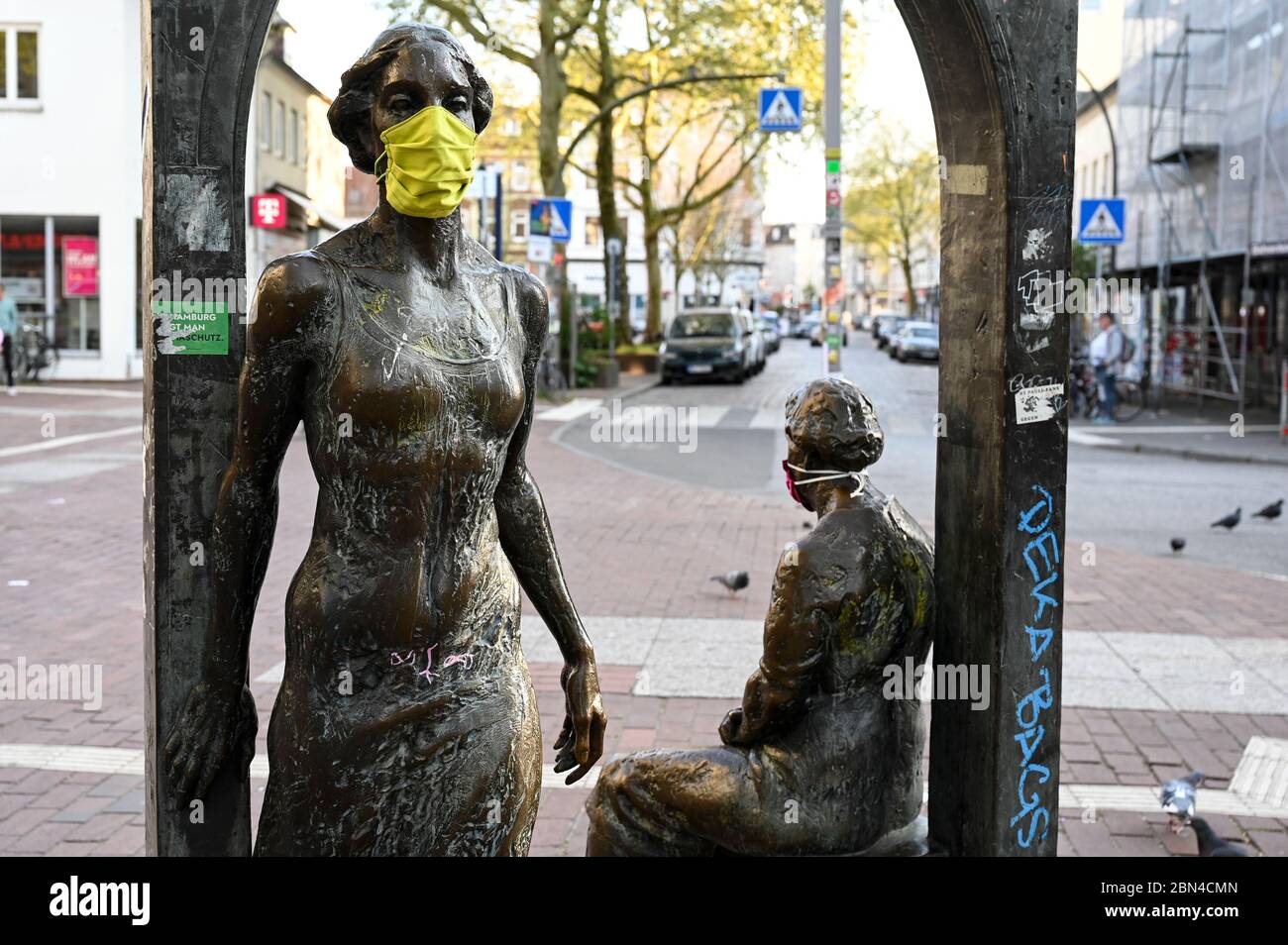 GERMANY, Hamburg, Ottensen, Corona Virus, COVID-19 , Ottenser Torbogen, two women sculpture by artist Doris Waschk-Balz , somebody has put a protective mask to protect them from Covid-19 Stock Photo