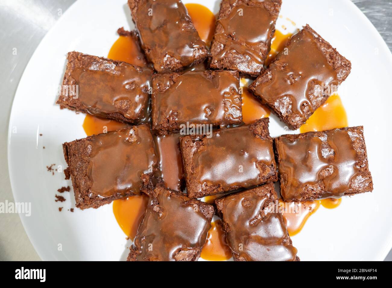 Top view on a plate with brownie pieces poured with salted caramel sauce Stock Photo