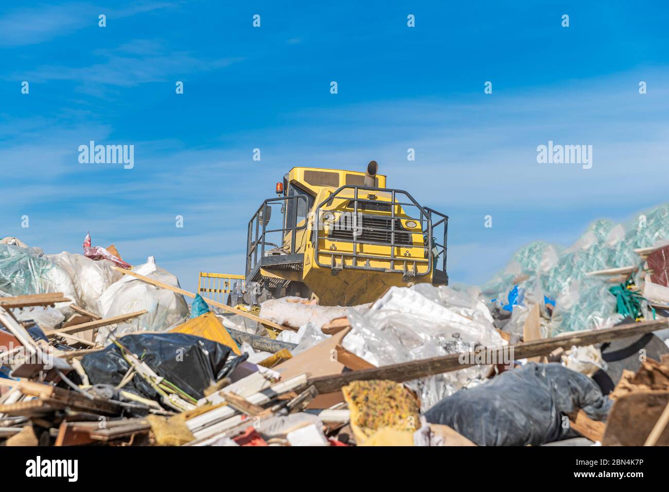 compactor processes waste at a landfill Stock Photo