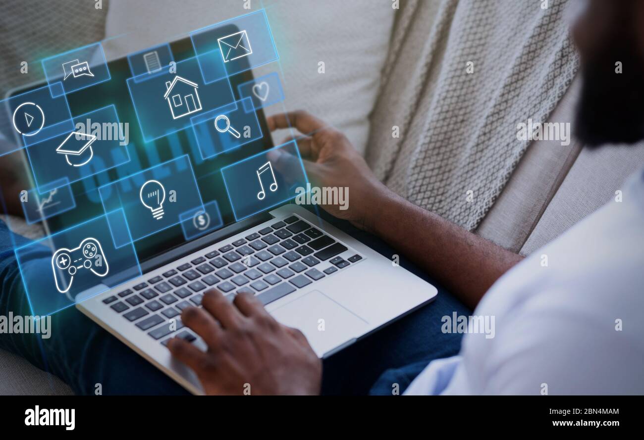 Internet life. African American guy with laptop at home, creative collage with various functional pictograms Stock Photo