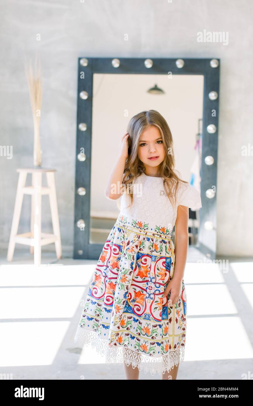 The lovely little girl posing in a beautiful blue dress Stock Photo - Alamy