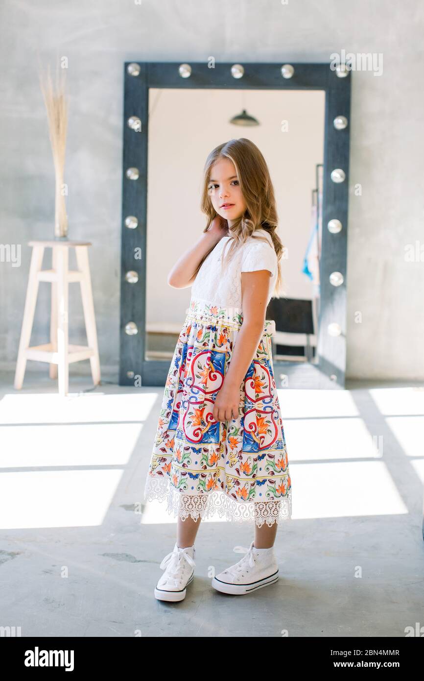 The lovely little girl posing in a beautiful blue dress Stock Photo - Alamy