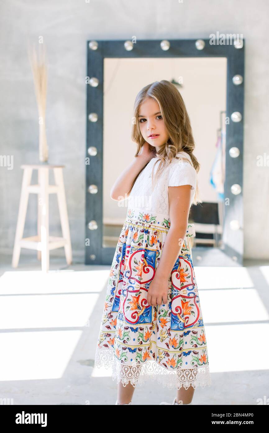 The lovely little girl posing in a beautiful blue dress Stock Photo - Alamy