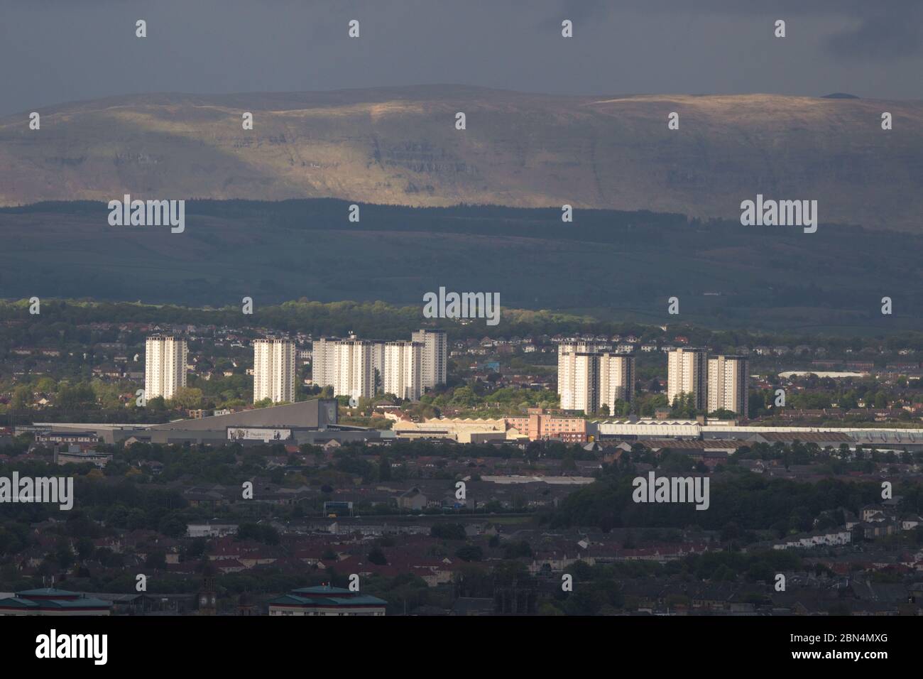 Glasgow, Scotland, UK. 12th May, 2020. Pictured: Looking North over Glasgow with the Campsie Fells in the background surrounded by a veil of rain and dark clouds with a cloud base of around 2,500ft. Cool evening temperatures as a blast of arctic air mass descends from the north with stead rain and strong but brief spells of sunshine through gaps in the cloud. Credit: Colin Fisher/Alamy Live News Stock Photo