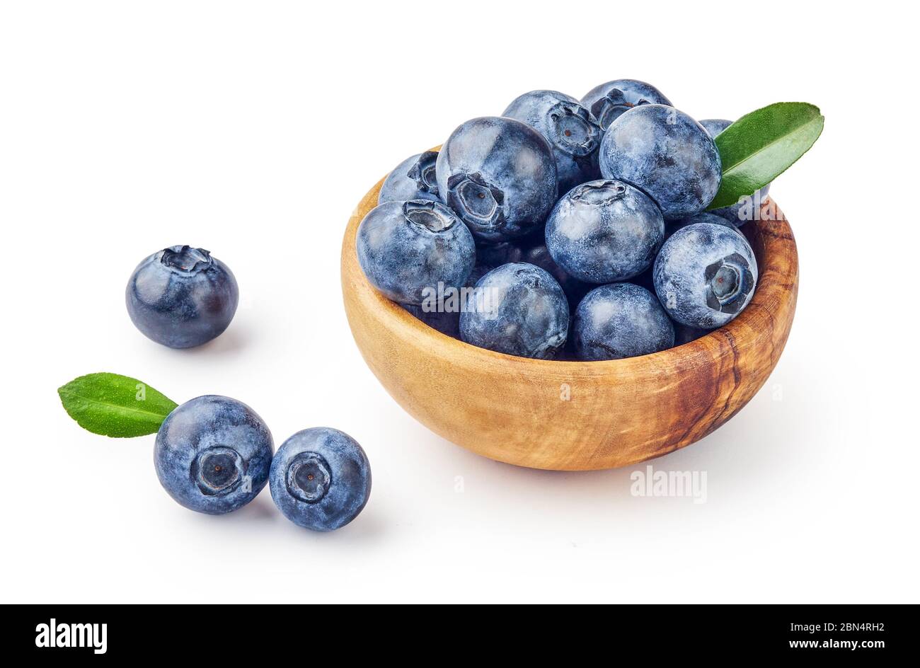 Fresh blueberries with blueberry leaves in wooden bowl isolated on white background. Stock Photo