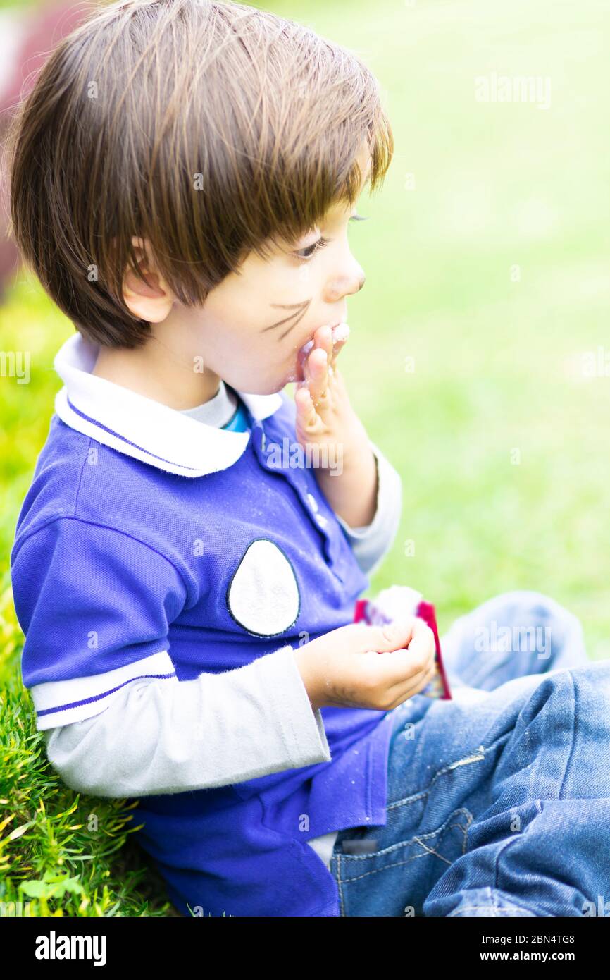 Happy Child Eating Delicious Food Outdoors Stock Photo - Alamy