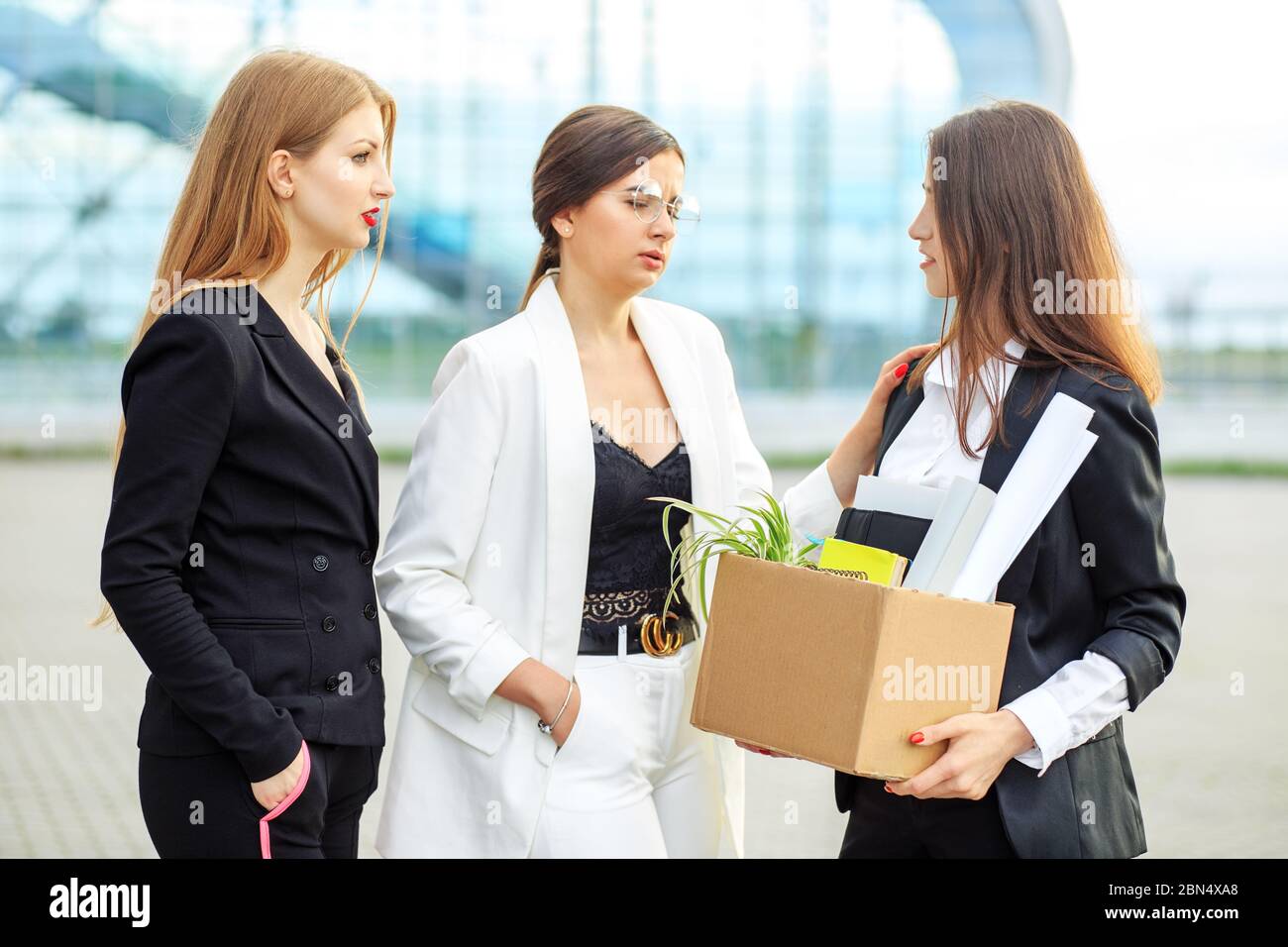 Layoffs from work. Woman says goodbye to colleagues. The end of a career. Concept for business, unemployment, labor exchange and dismissal. Stock Photo