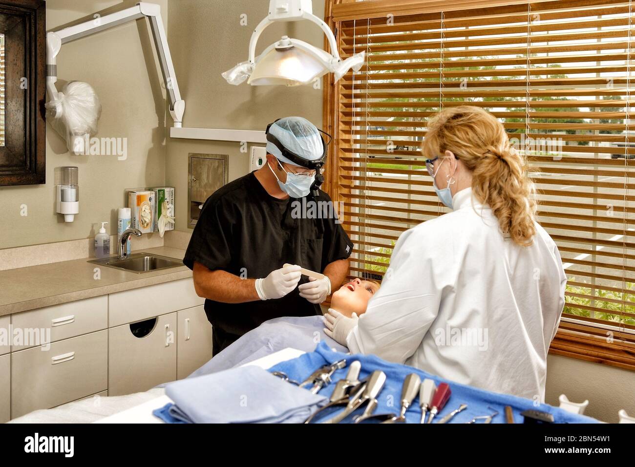 A dentist and dental hygienist performing an examination of a patient