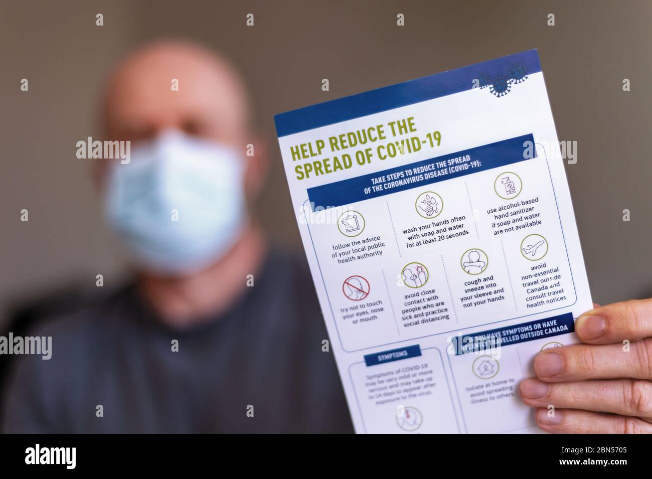 Montreal, CA - 12 May 2020: Man wearing a mask and holding Covid-19 safety guidelines. Stock Photo