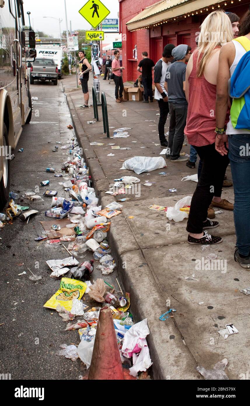 Austin Texas USA, March 2012: Garbage piles up in the street and on the sidewalk as young music fans stand in line outside a music venue waiting to hear bands during the South by Southwest Music Conference. ©Marjorie Kamys Cotera /Daemmrich Photography Stock Photo