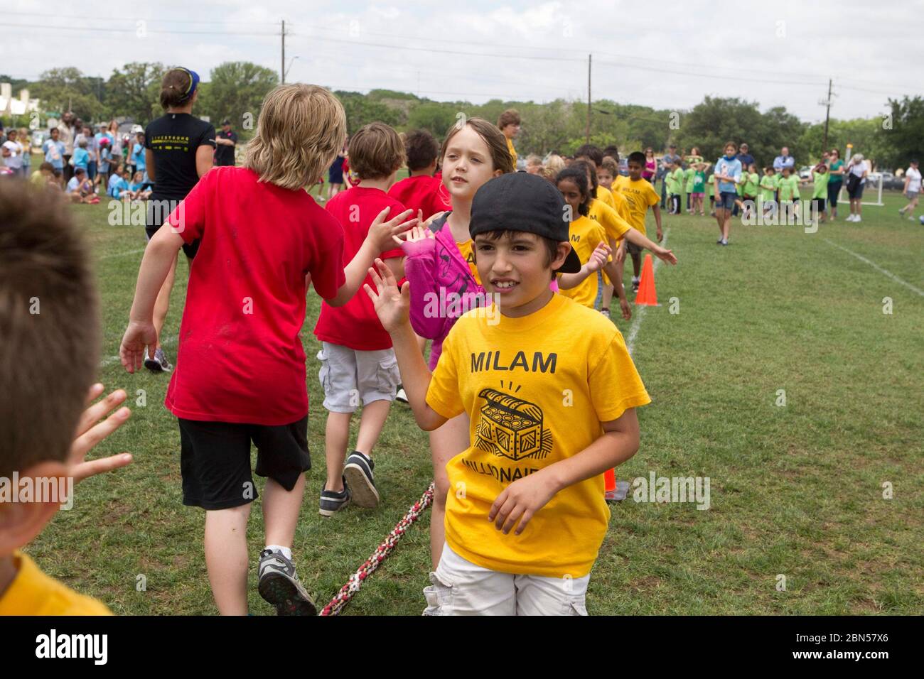 Austin Texas USA, May 10 2012: Group of multi-ethnic second grade elementary school students high-five each other after competing in tug-of-war game during school field day activities. ©Marjorie Kamys Cotera/Daemmrich Photography Stock Photo