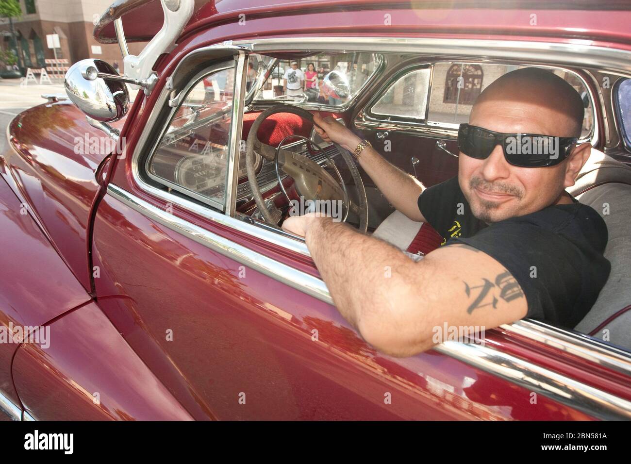 Austin Texas USA, March 2012: Hispanic man driving a restored classic low-rider car participates in a parade down Congress Avenue in  celebrating the unveiling of the Tejano Monument on Capitol grounds. The monument honors contributions of Tejanos, the Spanish-speaking settlers who brought cowboy culture to the state. ©Marjorie Kamys Cotera/Daemmrich Photography Stock Photo