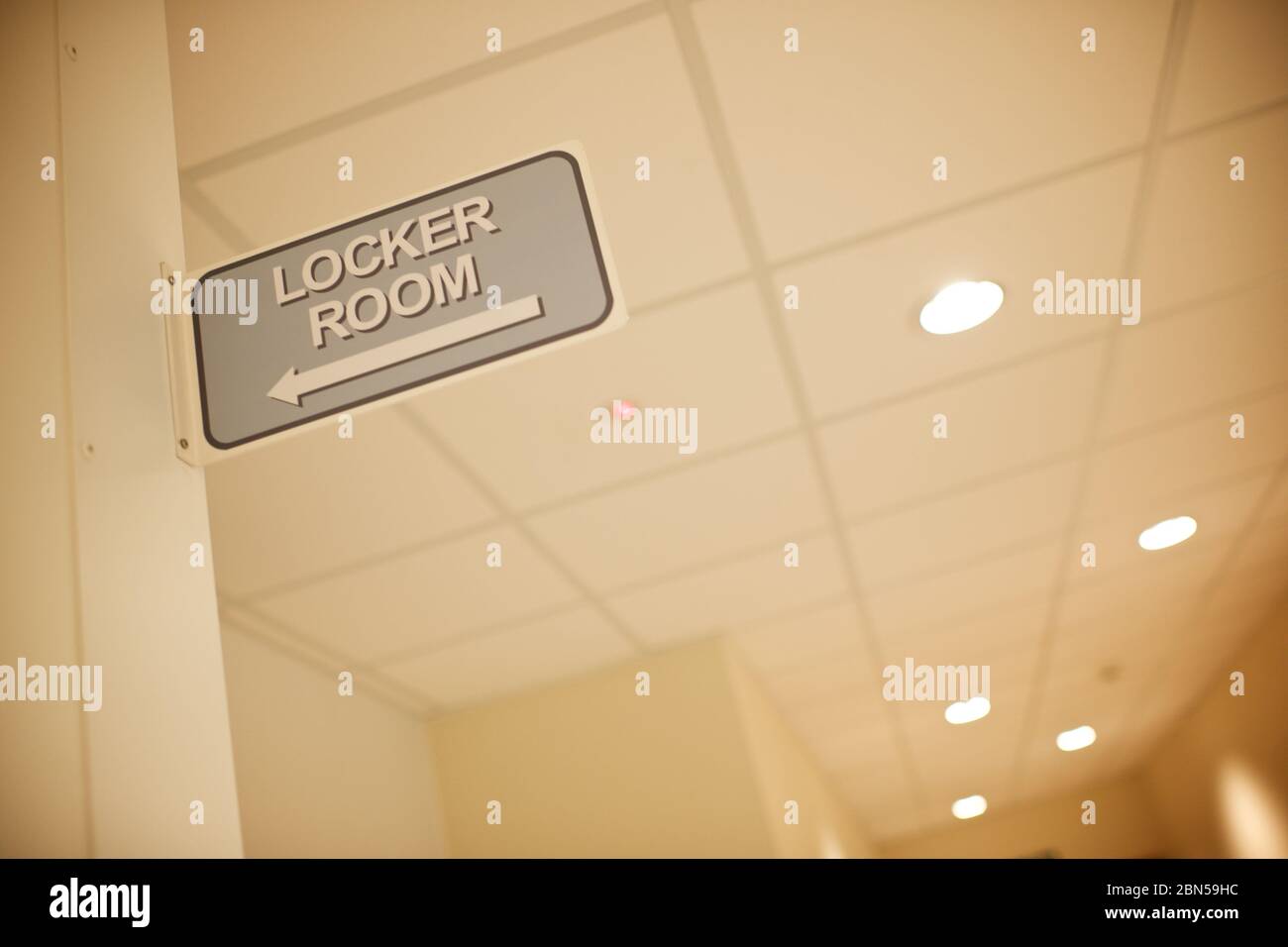 Beige locker room sign on a tiled wall inside a factory, Stock Photo