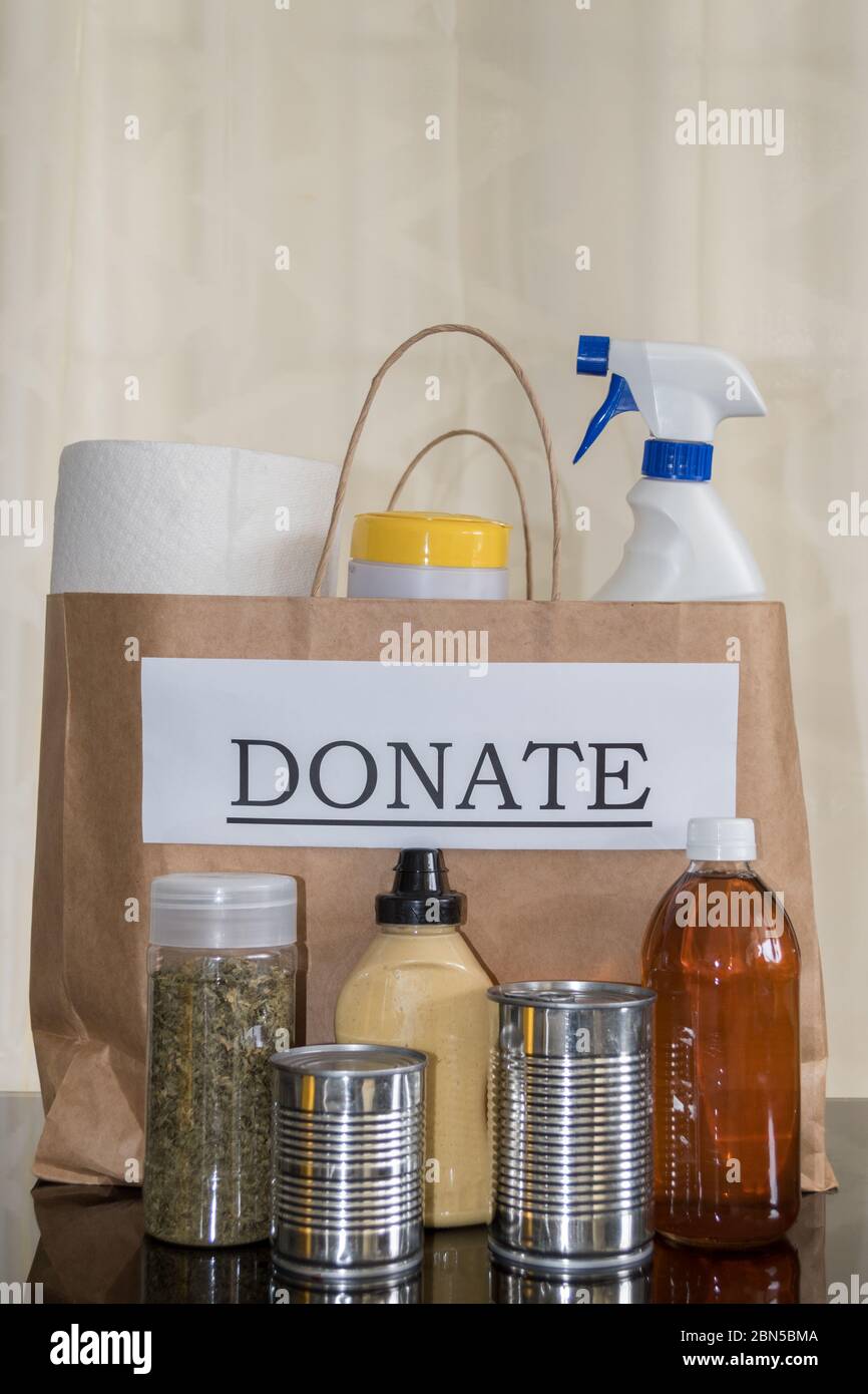 Preparing a donation box: an assortment of food and cleaning supplies ready to be packed for donation to those in need Stock Photo