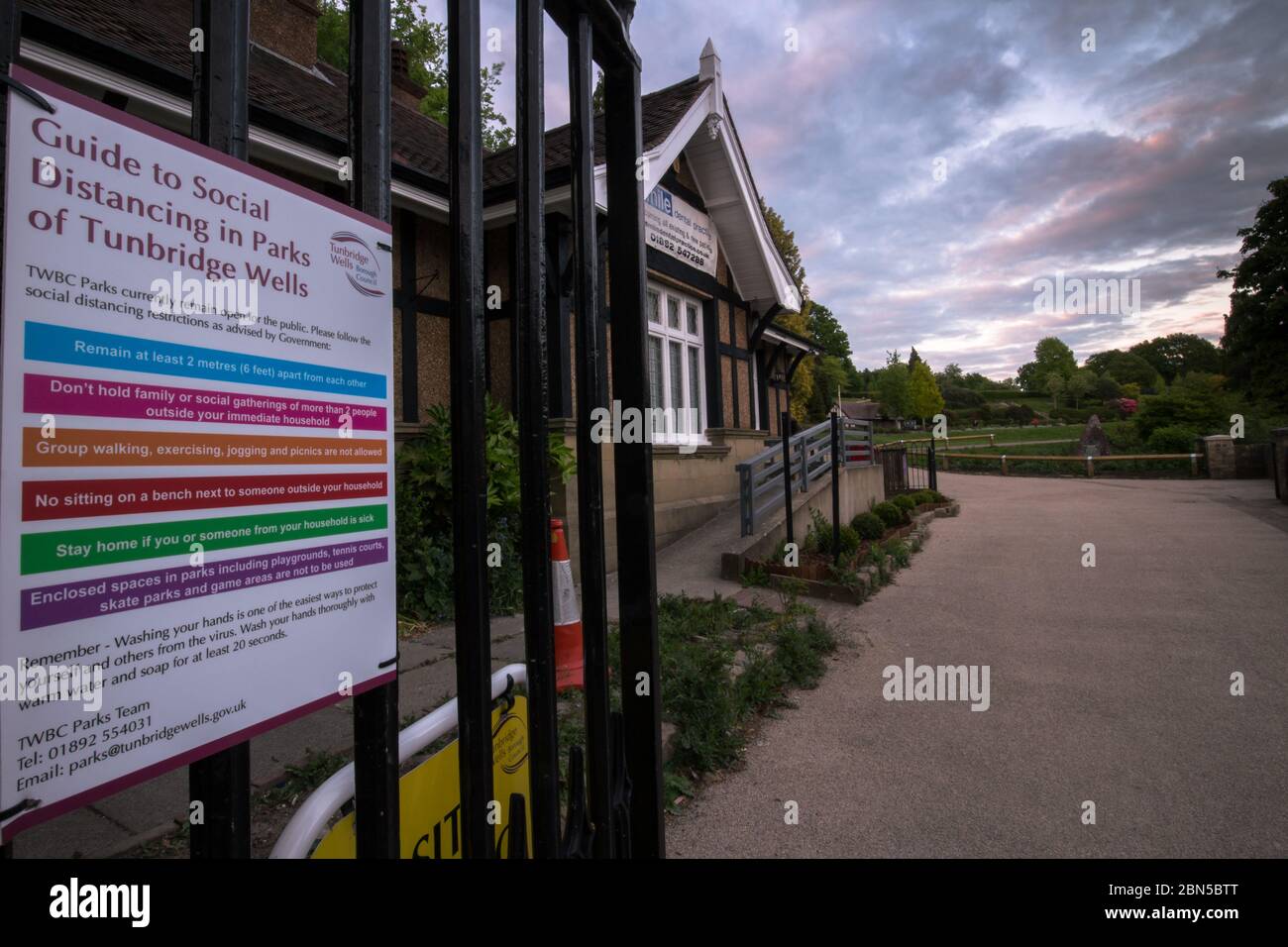Tunbridge Wells, England. 12th May 2020. The entrance to the town centre park has warning signs on the gates, the park is deserted,which is normally very busy at 9pm due to lockdown with Coronavirus with residents taking on board Government advice to stay home. © Sarah Mott / Alamy Live News Stock Photo