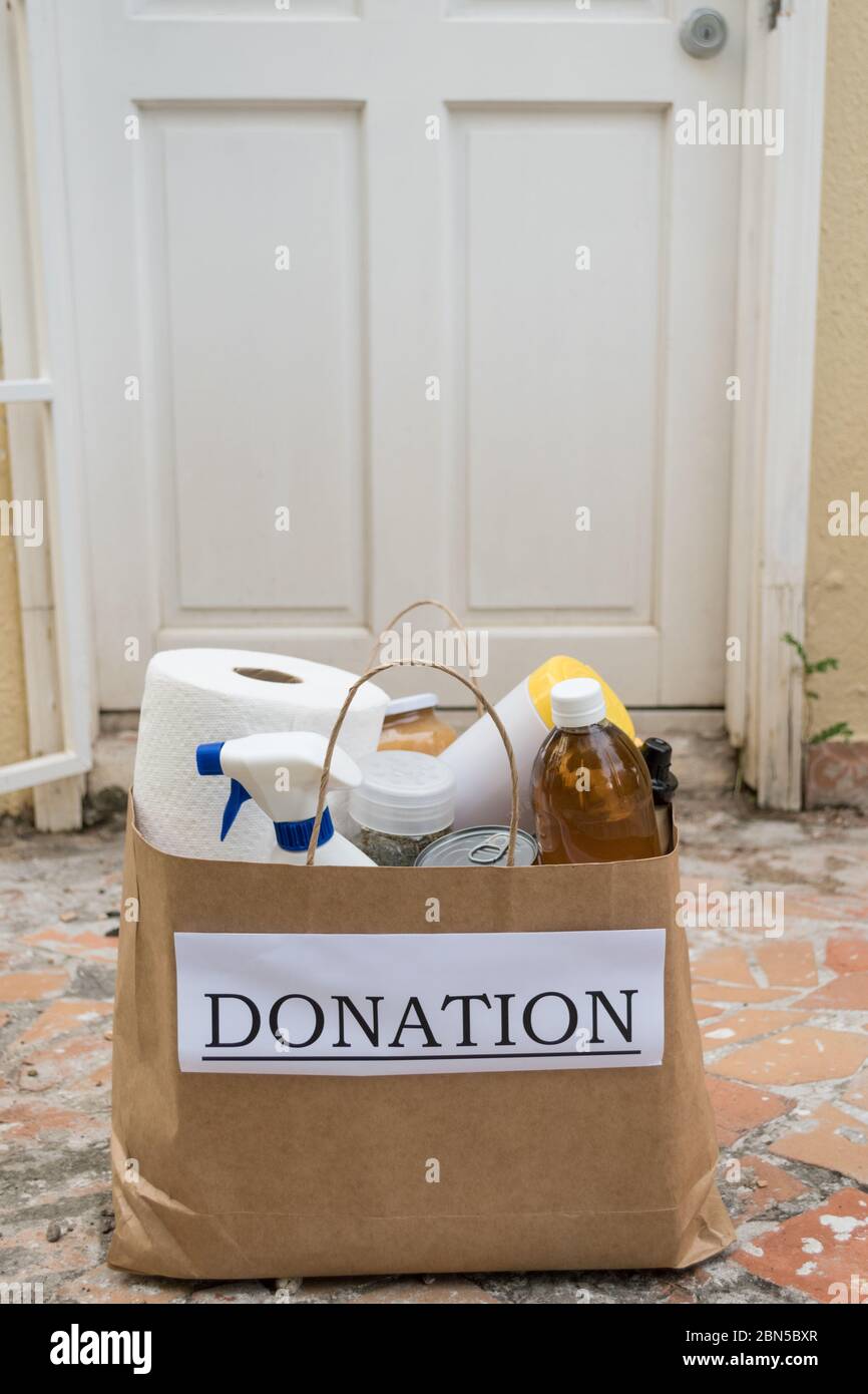 A donation bag filled with food and cleaning supplies is delivered to a home during the Covid-19 / Coronavirus Pandemic Stock Photo