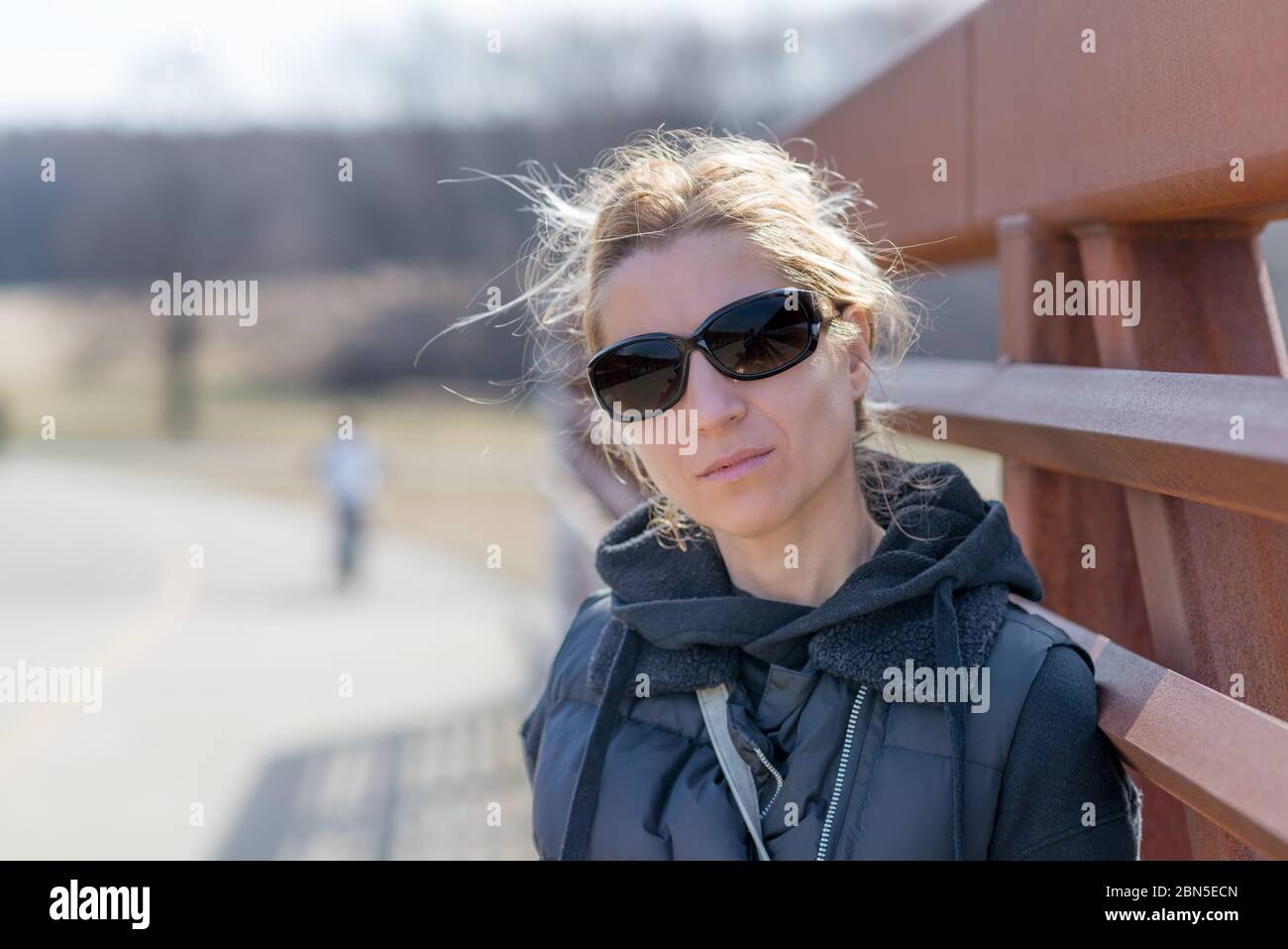 Portrait of a woman with black casual clothes in a park black sunglasses Stock Photo