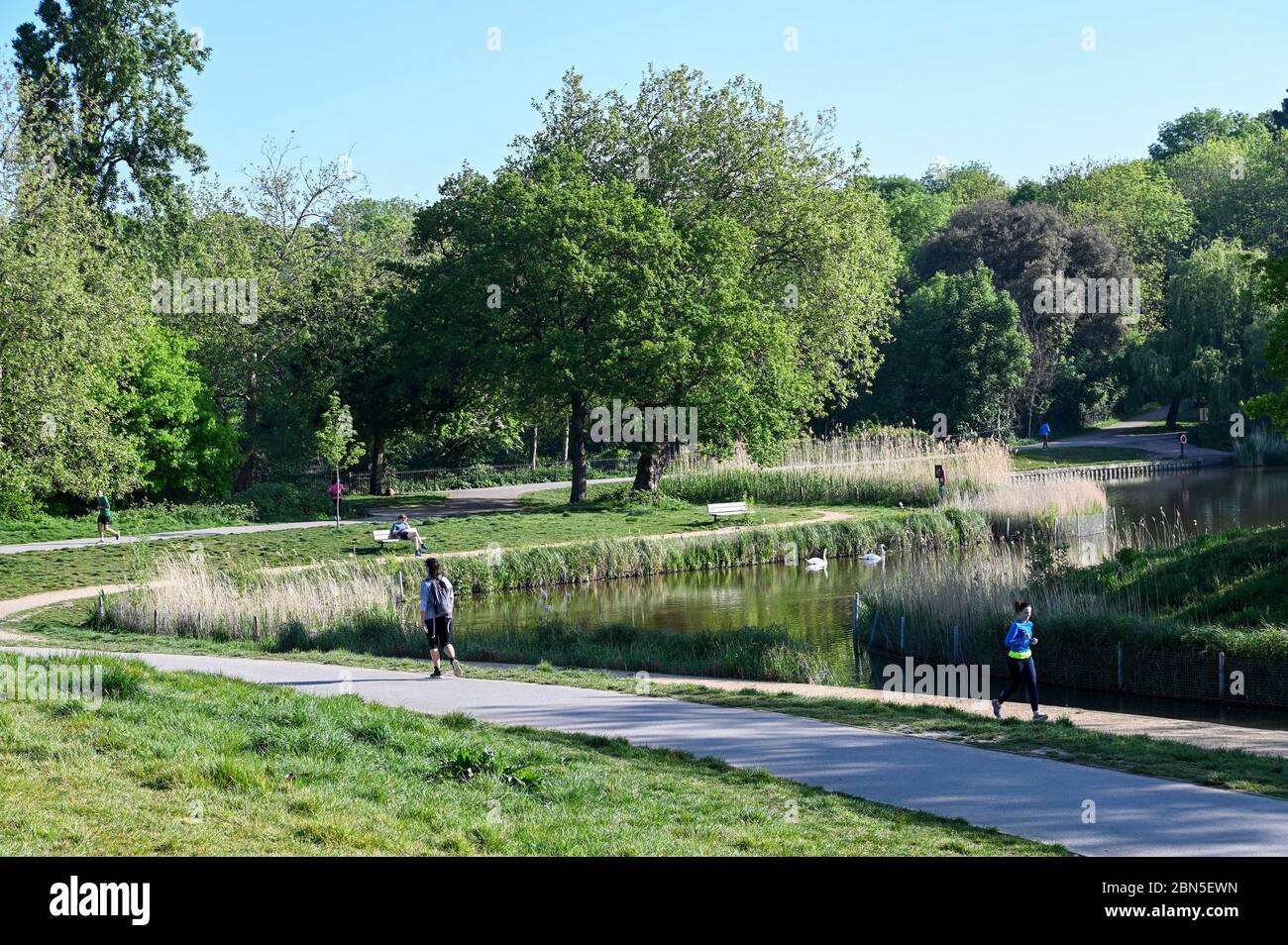 People running on Hampstead Heath observing social distancing during the Covid-19 pandemic. Stock Photo