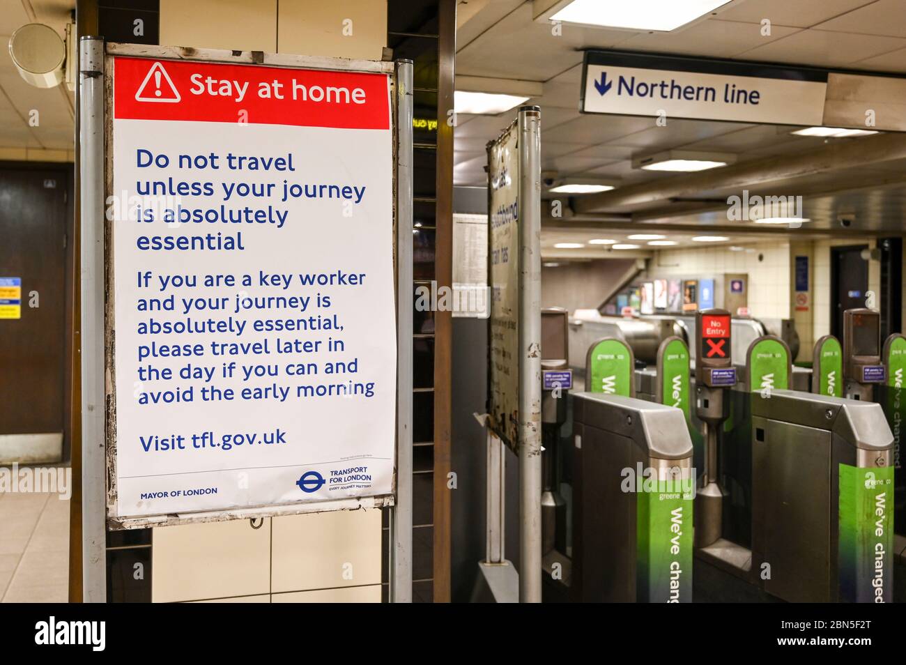 Notice next to tube station barriers to 'Stay at Home, no not travel unless your journey is absolutely necessary' during the coronavirus pandemic. Stock Photo