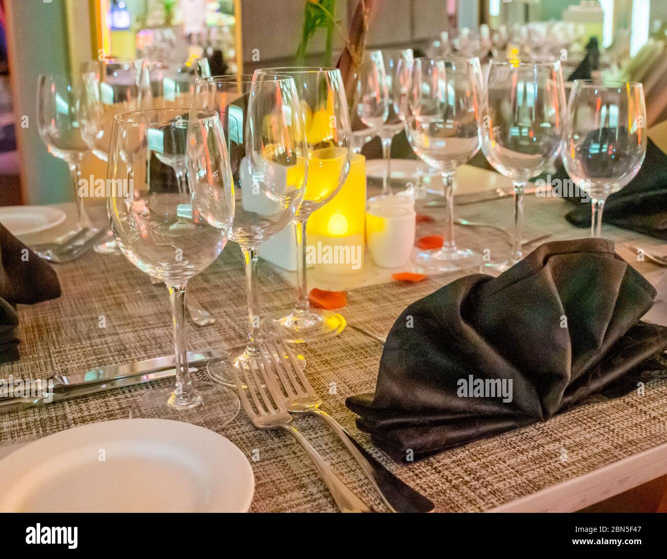 Romantic dinner table setup decoration with candle light in a restaurant. Selective focus Stock